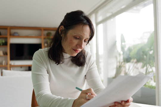 Woman Writes Notes at Home in a Bright Living Space