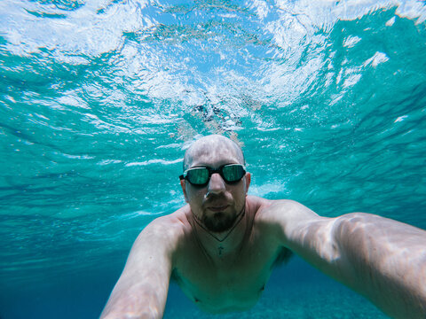 Man Swimming Underwater With Goggles