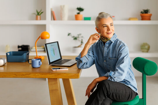 Senior woman working remotely from home office desk