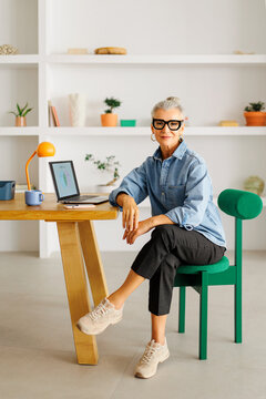 Mature woman working from home office with laptop