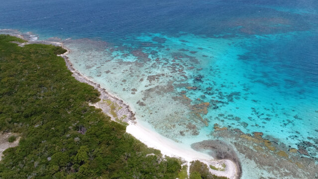 Aerial view of Los Roques archipelago with white sand beach, green vegetation, and turquoise coral reefs in the Caribbean Sea, Los Roques, Dependencias Federale, Venezuela.