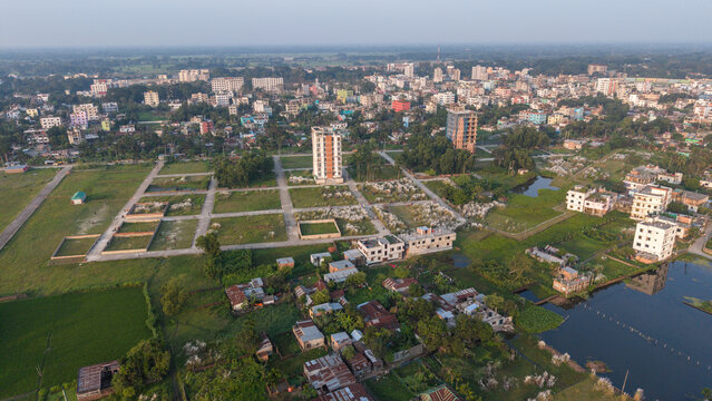 Aerial view of a developing residential area in bangladesh with new apartment buildings, plotted land, and surrounding rural landscape