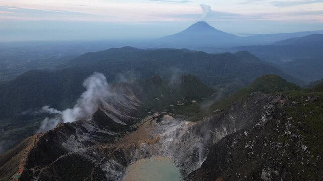 Drone video from the summit of an active volcano, Mount Sabayak with Mount Sinabung in the background, North Sumatra, Indonesia