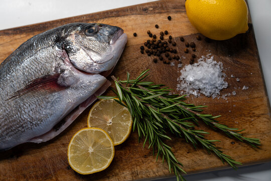 Fresh raw sea bream with lemon, rosemary, sea salt and black pepper