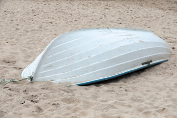An upside-down rowboat on a sandy Baltic Sea beach © marek_usz
