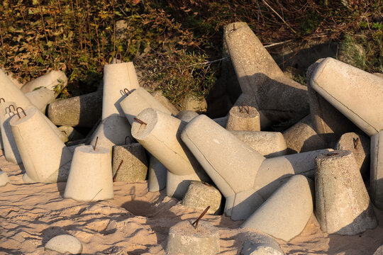 Multi-arm reinforced concrete blocks separate the beach from the dunes in Mielno, Poland, as seen here in the evening light