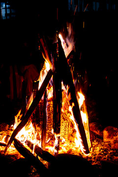 View of a bright bonfire with burning logs and glowing sparks at night in Arang Kel, Kashmir, Pakistan.