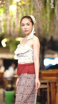 Slow motion of Asian woman in traditional Northern Thai dress holding a Lanna paper lantern.