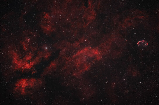 View of the Butterfly Nebula in the constellation Cygnus, showcasing vibrant red ionized hydrogen gas clouds and dense star fields in Poland.