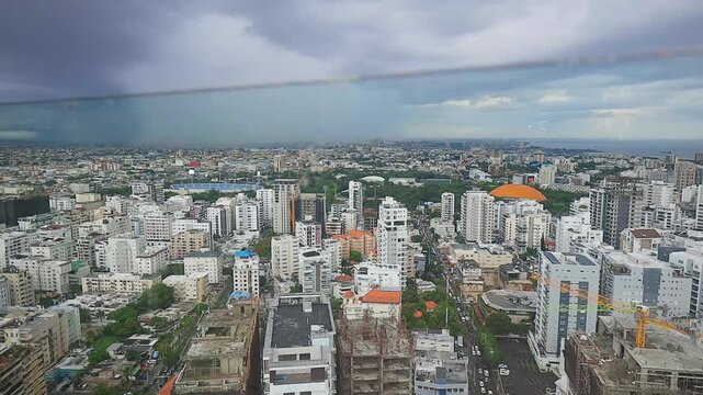 Panoramic aerial view of a sprawling city under a dramatic sky with approaching storm clouds