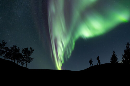 Silhouette of a team at the northen light background. Sport and active life concept and idea of team