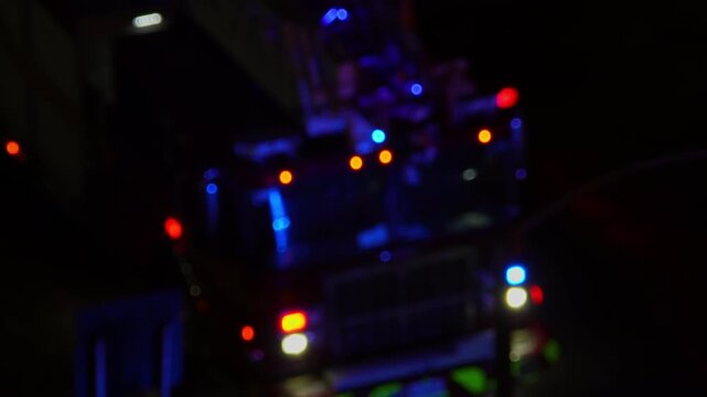 Fire truck first responders with flashing emergency lights at night fire accident scene. Blurry fire truck with glowing lights responding and arrive to emergency call alert. Emergency siren flashing.