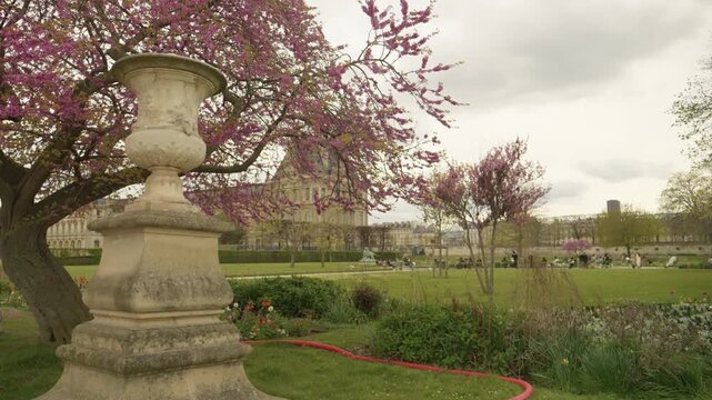 Tuileries Garden with Historic Louvre Palace and Classical Statue in Paris, France