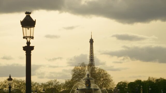 Eiffel Tower Seen Through Trees and Historic Street Lamps in Paris, France