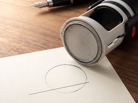 Self Inking Stamp Beside Faint Circle Seal And Line On Paper