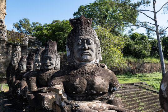 View of ancient stone statues of asuras and devas lining the causeway at the entrance of Angkor Thom, with weathered carvings in Krong Siem Reap, Siem Reap Province, Cambodia.