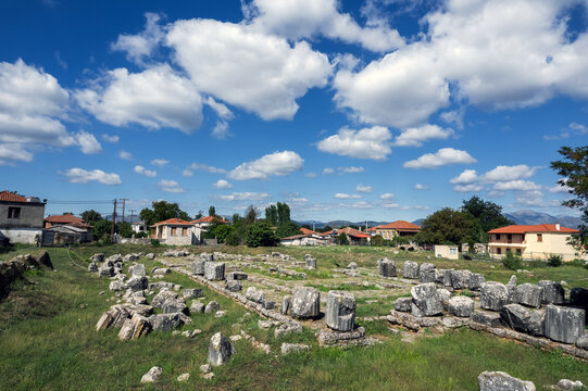 The surviving foundations and architectural blocks of the Temple of Athena Alea at Tegea, 4th century BC, with a modern church standing immediately beside the ancient sanctuary.