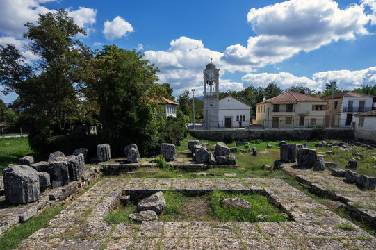 The surviving foundations and architectural blocks of the Temple of Athena Alea at Tegea, 4th century BC, with a modern church standing immediately beside the ancient sanctuary.