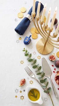 Blue and gold hanukkah flatlay with menorah olive oil and festive table setting decorations