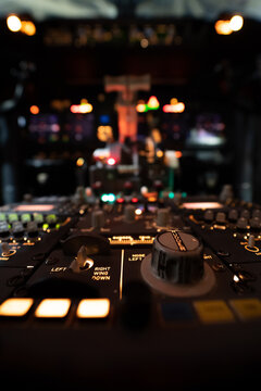 View of the illuminated cockpit control panel of a Boeing 737-800 aircraft with glowing switches and knobs at Hannover Airport in Langenhagen, Niedersachsen, Germany.