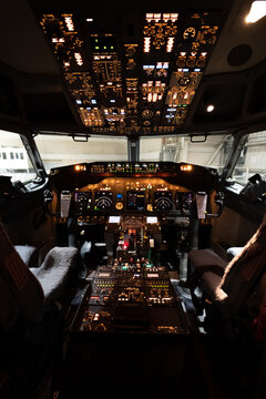 View of the illuminated cockpit of a Boeing 737-800 aircraft with detailed flight instruments and control panels at Langenhagen, Niedersachsen, Germany.
