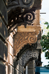 Ornate carved stone corbels decorate the facade of a historic European building © watcherfox