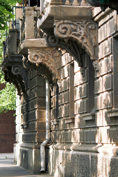 Ornate carved stone corbels decorate the facade of a historic European building