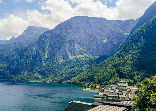 View of Hallstatt village nestled between the Hallstatter See and steep forested mountains, with traditional architecture and clear blue water Hallstatt, Upper Austria, Austria.