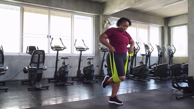 African American woman training with resistance bands in a gym, improving strength, mobility and fitness while promoting healthy aging.	