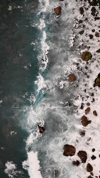 Top down view of rough ocean water with foam patterns and turbulence, natural abstract background