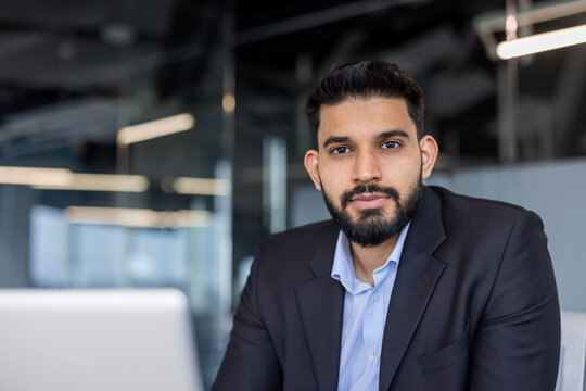 Professional businessman with beard looking at camera in office