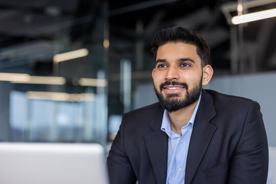 Smiling young businessman looking away in office setting