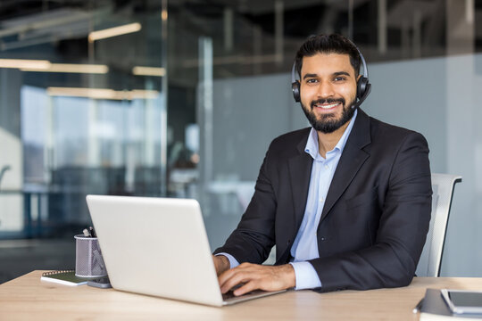 Smiling bearded businessman wearing headset providing customer support