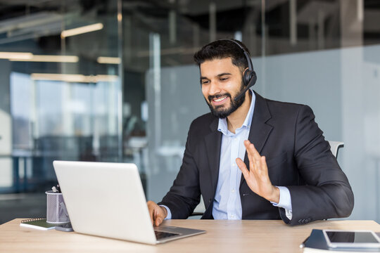 Business man having video call using laptop and headset