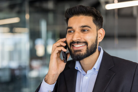 Professional businessman talking on smartphone in office environment