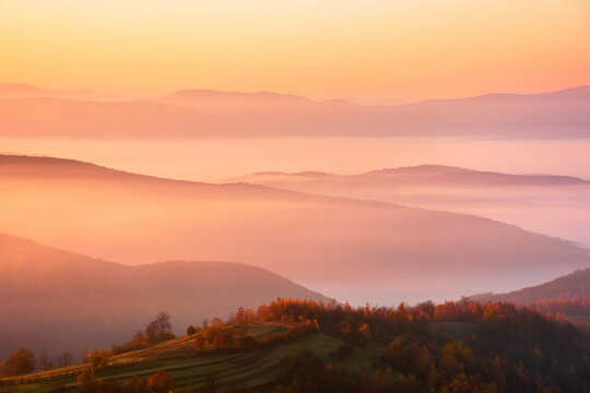 cold morning fog with red hot sunrise in the Carpathian mountains. rural valley of Perechyn district in morning mist. nature background with fog rolling over hillls