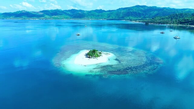 Aerial view of a tropical island with turquoise water and distant