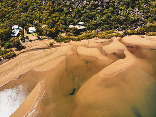 Aerial view of tidal sand banks and shallow water at low tide beside holiday houses in tropical forest with granite boulders, Magnetic Island, Australia © Florian