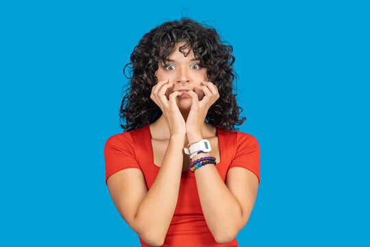 Anxious young woman biting nails in fear