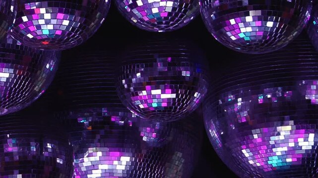 Mirrored Sphere Cluster Glows Under Blue and Purple Lighting. Packed reflective spheres fill the dark interior while tiled mirror surfaces scatter changing light into shimmering abstract patterns.