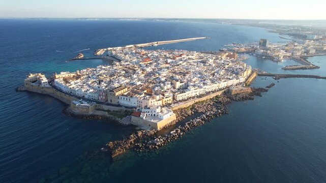 Aerial drone - circling flight path - shot of Gallipoli old town island surrounded by turquoise Ionian sea, Salento, Puglia, Italy