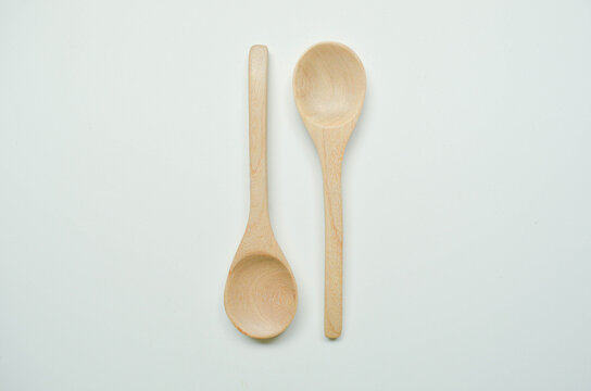 Natural wooden cups and kitchen utensils on minimal white background