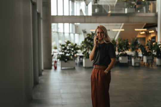 Businesswoman talking on phone in modern office environment