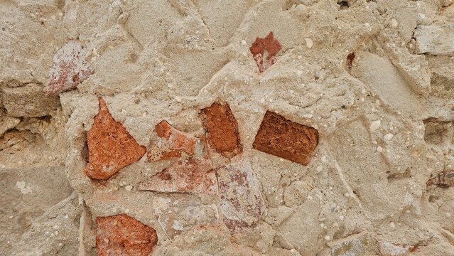 Rustic red brick fragments background texture with rough sandy cement mortar