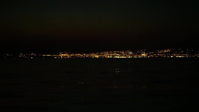 City lights sparkle over water in Rijeka during night.