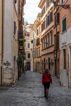 A Young Woman Walking Through a Quiet Traditional Alleyway in the Center of Rome