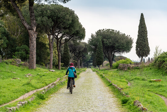 Young Woman Cycling on Via Appia Antica, Rome