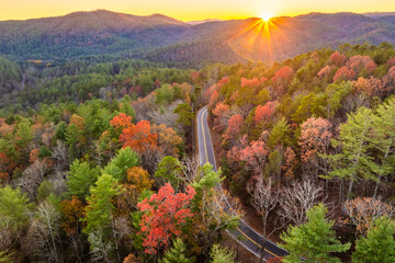 Obraz premium Blue Ridge Parkway at sunset in autumn. Scenic route between majestic mountain hills covered in golden and scarlet leaves