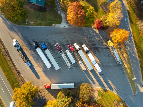 Big parking car and truck stop for tractor trailers and personal vehicles. Rest area near busy American highway. Hauling cargo concept.