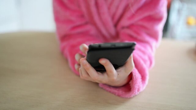 Little beautiful girl plays on her mobile phone